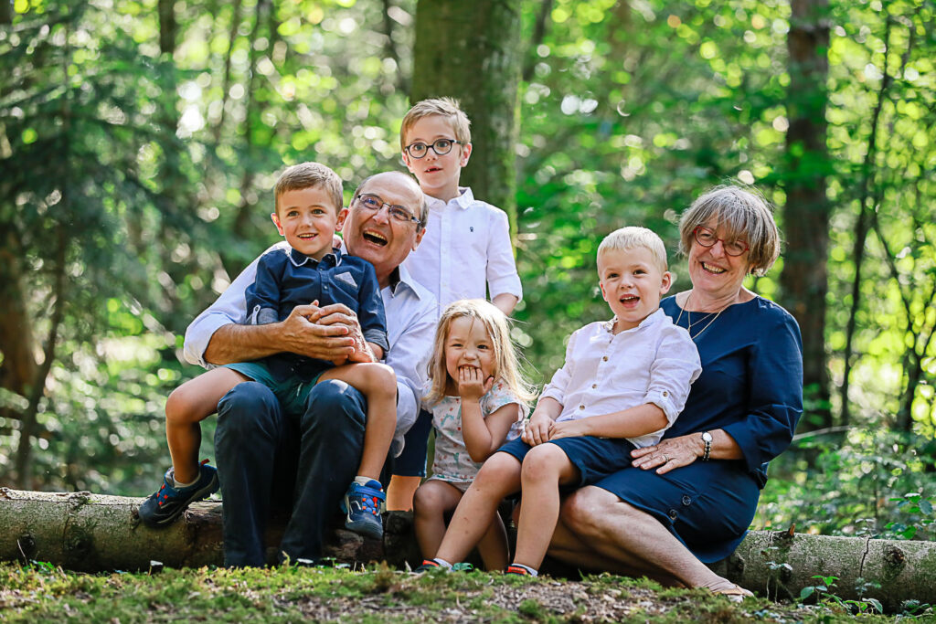Séance photo intergénérationnelle - grands parents et les petits enfants tous assis sur un arbre